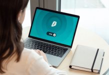 Przestępstwa komputerowe w kodeksie karnym – co grozi i jak się chronić Kobieta przy biurku korzysta z laptopa z włączoną aplikacją VPN