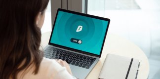 Kobieta przy biurku korzysta z laptopa z włączoną aplikacją VPN