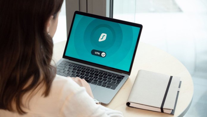 Kobieta przy biurku korzysta z laptopa z włączoną aplikacją VPN