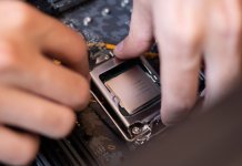 Podkręcanie procesorów: Athlon XP, Duron i Tualatin – mostki, pinmody i dzisiejszy overclocking Dłoń montująca procesor w gnieździe płyty głównej z bliska